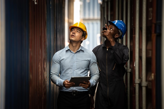 Caucasian worker use smartphone and tablet about business working at the port for transfer products