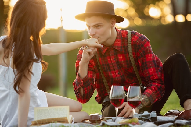 Caucasian young and happy couple enjoying a picnic in the park on summer day