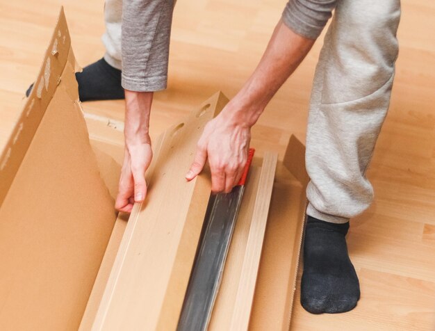 Photo a caucasian young man in gray sports and black socks takes out a wooden plank for a bed