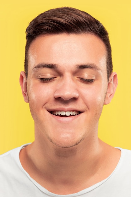 Caucasian young man's close up portrait on yellow background