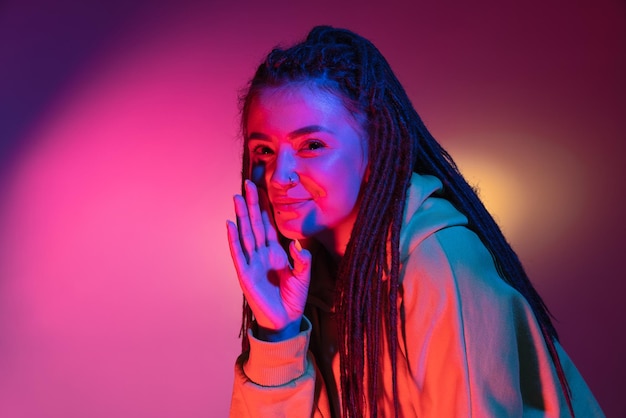 Caucasian young woman's portrait on dark studio background in neon Concept of human emotions facial expression