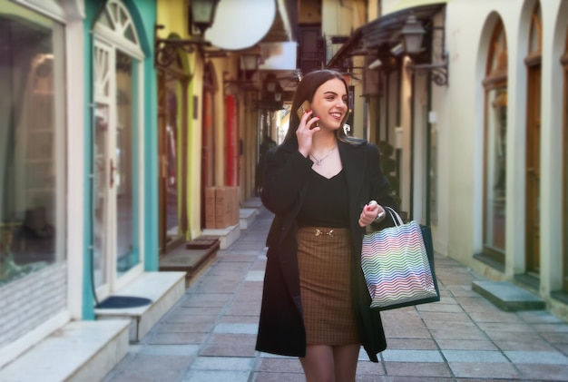 Caucasian young woman walking outdoor holding shopping bags