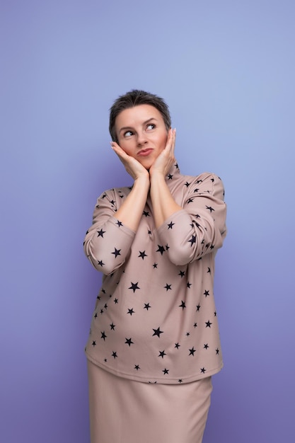 Caucasian young woman with a short haircut dressed in a beige suit consisting of a skirt and a