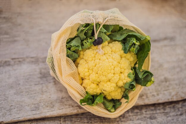 Cauliflower in a reusable bag on a stylish wooden kitchen surface Zero waste concept