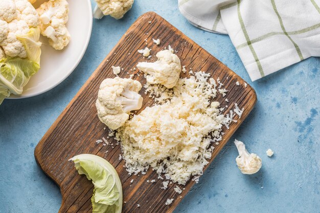 Cauliflower rice in a bowl on light stone background with free text space.