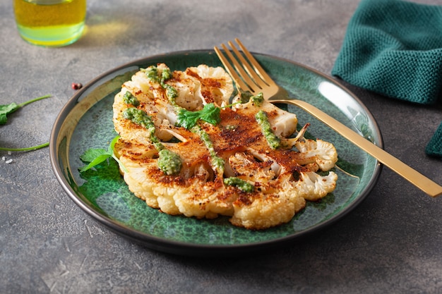 Cauliflower steaks with herb sauce and spice. plant based meat substitute