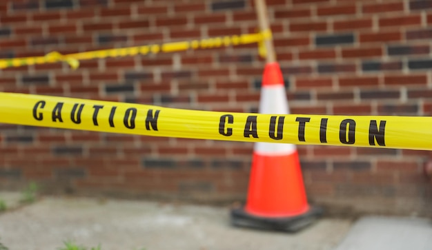 A caution cone is shown on a brick wall.