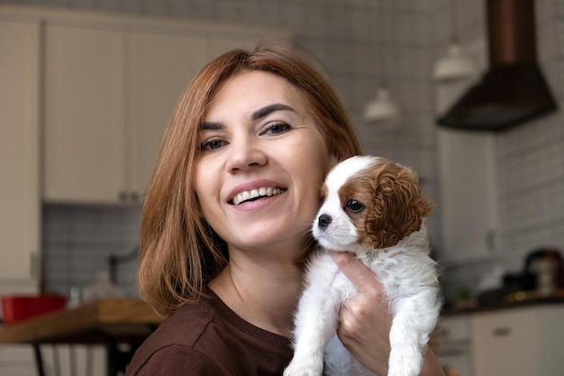 Cavalier King Charles Spaniel Blenheim Close up portrait of Cute dog puppy with woman hostess