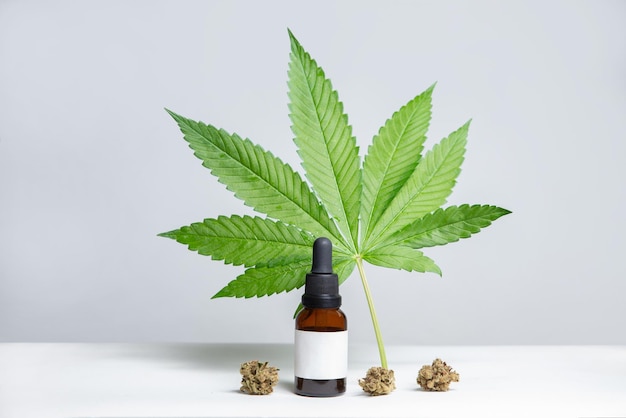 CBD dropper, hemp oil extract, cannabis leaf on white background