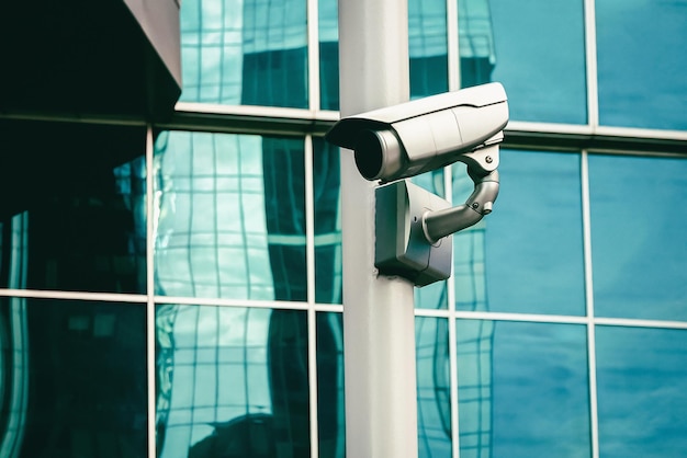 Cctv camera surveillance camera outside of glass building wall