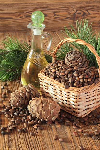 Cedar cones, nuts and cedar nut oil in a transparent bottle on a wooden table