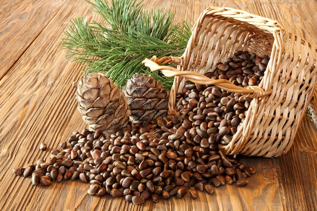 Cedar nuts and cedar cones in a wicker basket on a wooden table