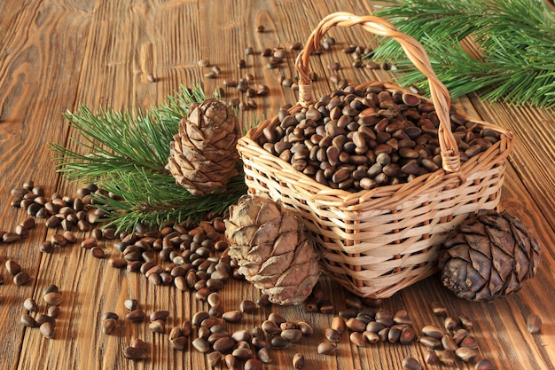 Cedar nuts and cedar cones in a wicker basket on a wooden table