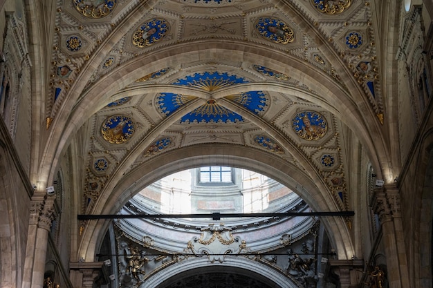 The ceiling of a church is decorated with gold and blue designs