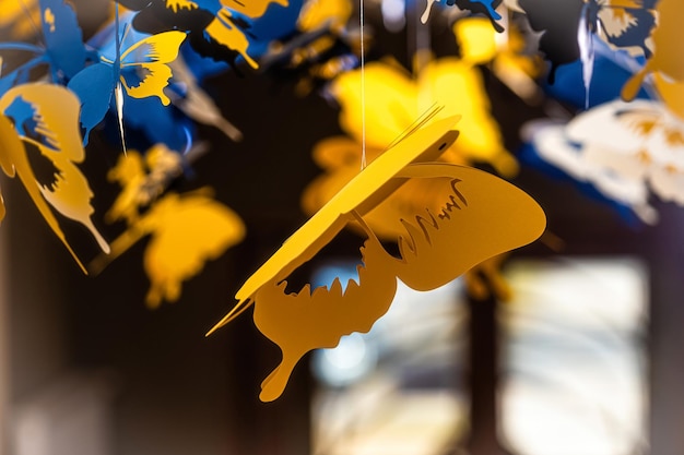 Ceiling decorated with decorative colored paper butterflies selective focus blurred background