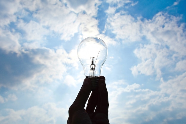 Ceiling lamp in hand on blue sky background