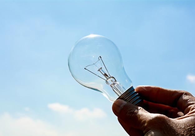 Ceiling lamp in hand on blue sky 