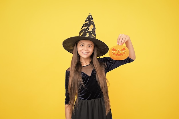 Celebrate the holidays jack o lantern halloween witch girl happy childhood teenage child in witch hat cheerful kid holding pumpkin carnival costume party trick or treat Monster of a Sale