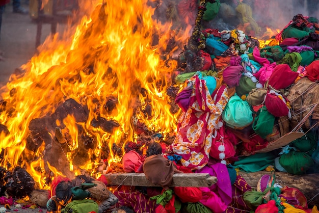 Celebrating Holika Dahan by worshiping and setting fire of wood logs or coconut also known as the festival of colors Holi or the festival of sharing