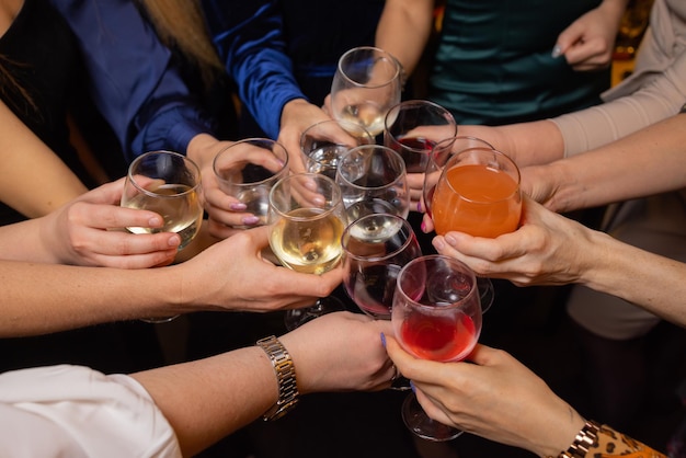 Celebrating with glasses of alcohol in hands happy female friends having good time