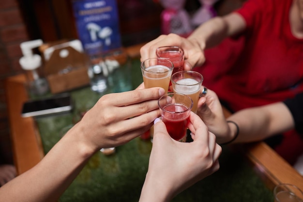 Celebrating with glasses of alcohol in hands happy female friends having good time