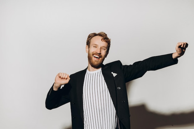 Celebration concept Stylish redhaired young man in a black jacket isolated on a white background