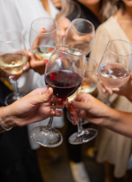 Celebration. People holding glasses of white wine making a toast.