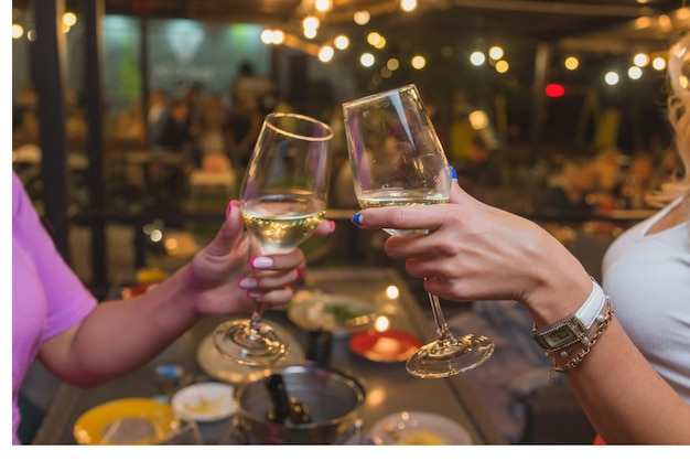 Celebration people holding glasses of white wine making a toast