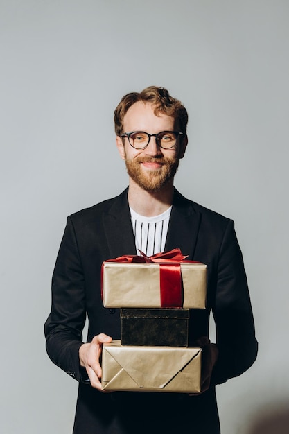 Celebration Time Portrait of a happy guy holding stack of present boxes isolated over white background at studio