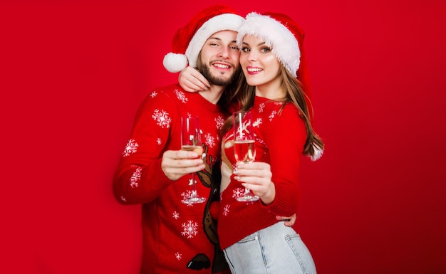 Celebreating christmas and new year couple in santa hat with glasses of champagne