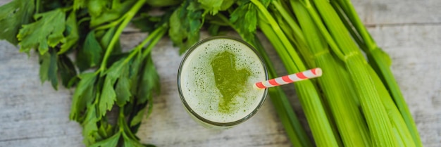 Celery juice healthy drink bunch of celery on a wooden background banner long format