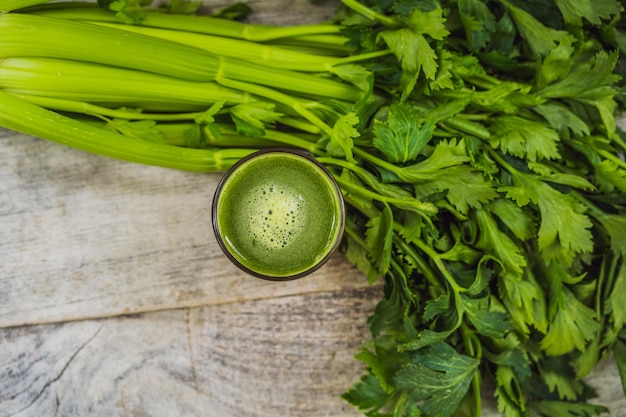 Celery juice healthy drink bunch of celery on a wooden background