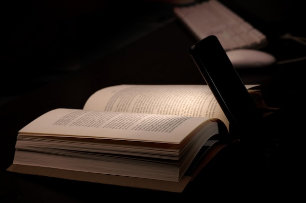 cell phone and power bank on the desk illuminates reading and study book with battery-powered comput