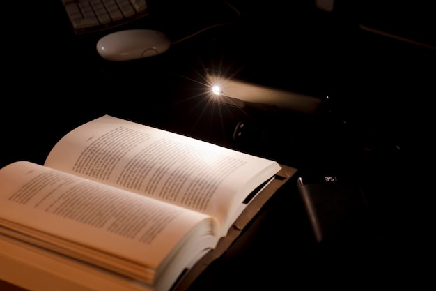 cell phone and power bank on the desk illuminates reading and study book with battery-powered comput