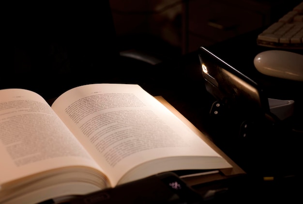 cell phone and power bank on the desk illuminates reading and study book with battery-powered comput