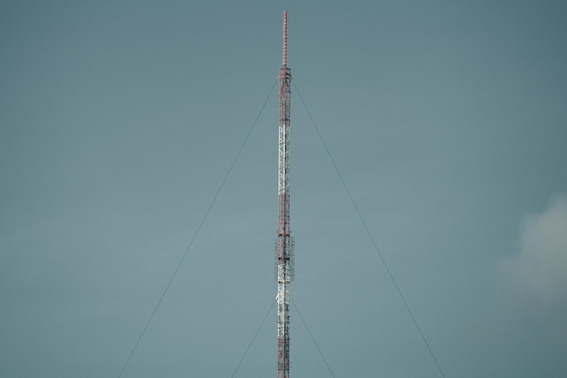 A cell phone tower with a dark sky behind it