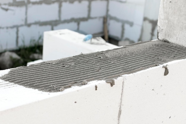 Cement on the block wall before laying the blocks Applying glue to the wall in the construction of the house