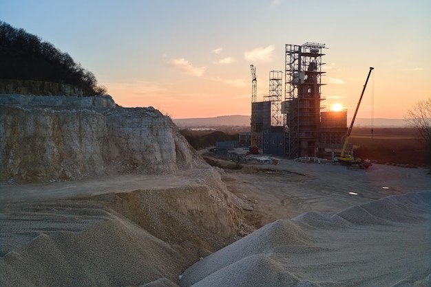 Cement factory at open pit mining of construction sand stone materials Digging of gravel resources at quarry at sunset