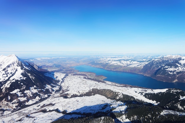 The center of Bernese Apline city in Interlaken at winter Swiss Alps, helicopter view. Thun Lake on the background