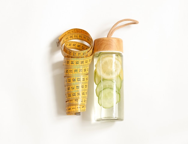 A centimeter and a bottle of detox on a light background.