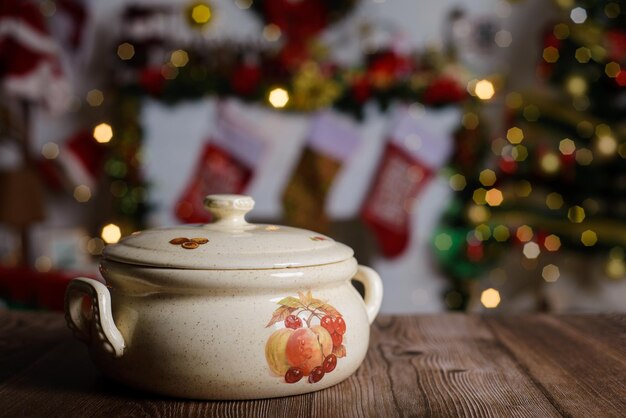 Ceramic cooking pot on wooden table Background with Christmas decorations