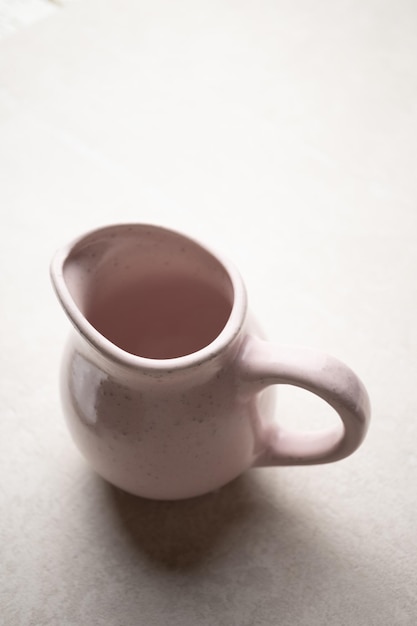 Ceramic jug for liquid products closeup on a light background kitchen utensils