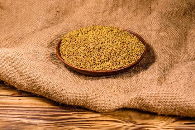 Ceramic plate with fenugreek seeds on a sackcloth