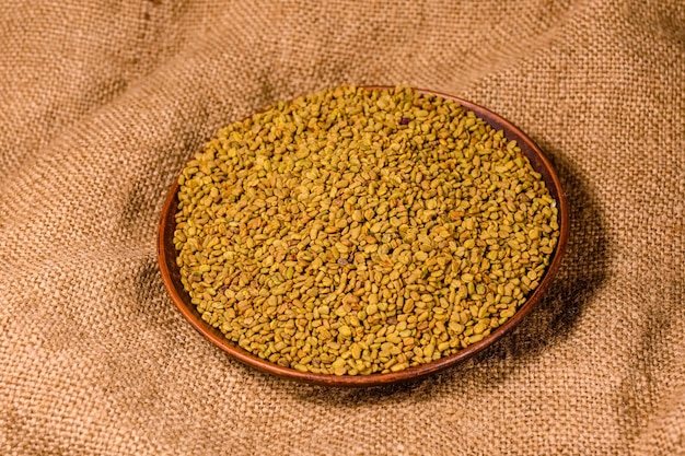 Ceramic plate with fenugreek seeds on a sackcloth