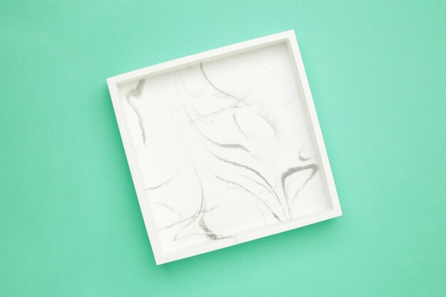 Ceramic square tray on a mint background Top view