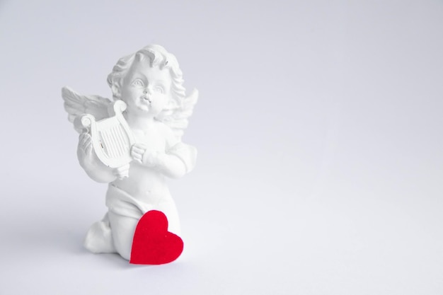 Photo ceramic white angel on white background.copy space.