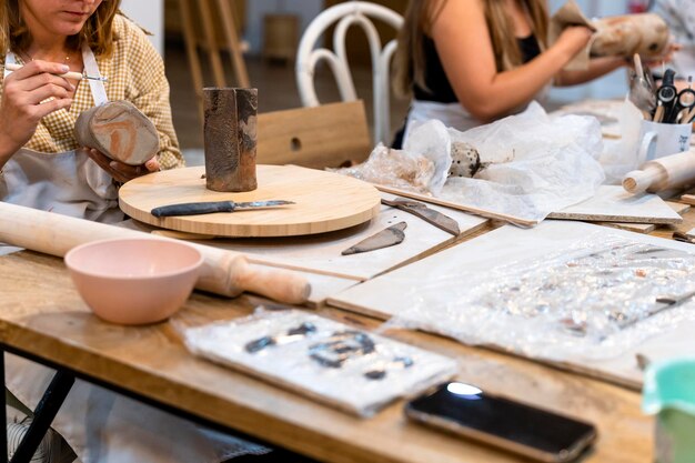 Photo ceramic workshop middle aged woman repairing pottery