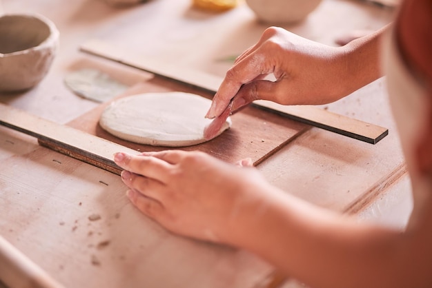 Ceramics pottery and design with hands of woman in workshop studio for mold creative and art Clay sculpture and manufacturing with girl artisan on table for crafting handmade and hobby