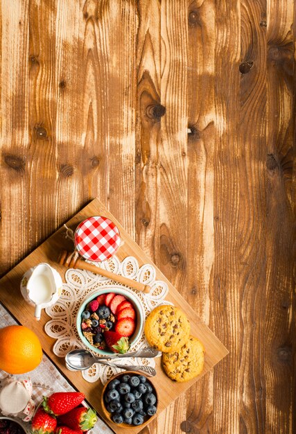 Cereal. Breakfast with muesli and fresh fruits in bowls on a rustic wooden background