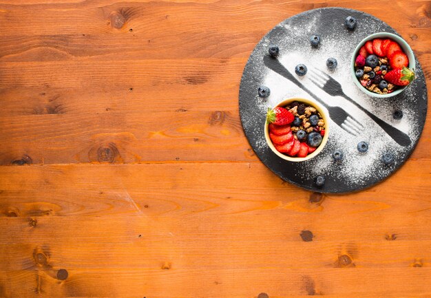 Cereal. Breakfast with muesli and fresh fruits in bowls on a rustic wooden background